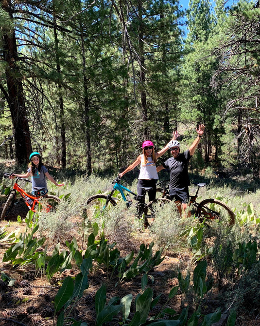 Four people with bicycles in a forest setting